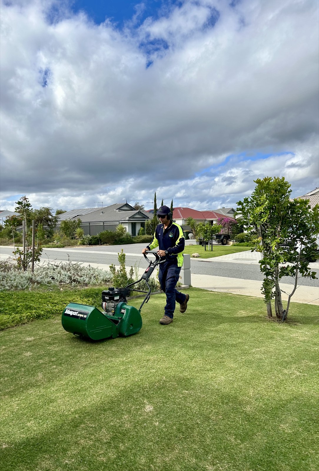 Mitch from Lagoon Lawns & Gardens mowing a front lawn with a cylinder mower